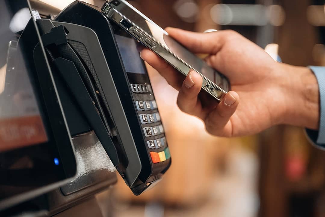 Person using wireless payment via phone in a payment terminal.